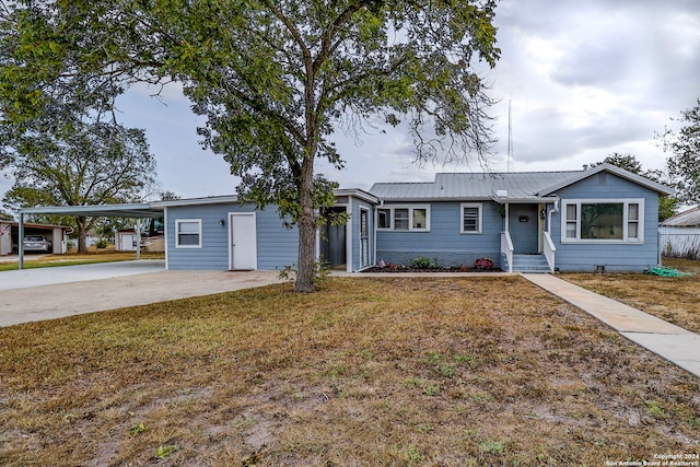 single story home featuring a front lawn and a carport