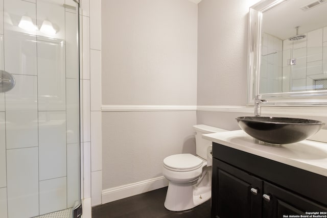 bathroom with toilet, an enclosed shower, and vanity