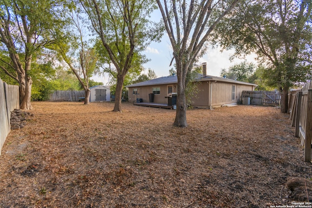 view of yard with a wooden deck and a storage shed