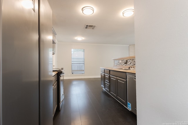 kitchen with stainless steel appliances, sink, dark wood-type flooring, and backsplash