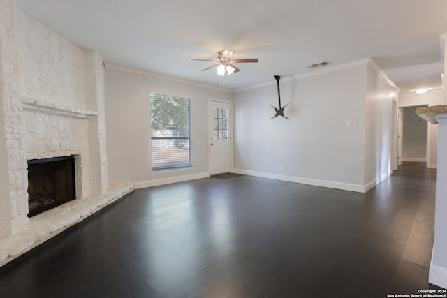 unfurnished living room with dark wood-type flooring, ceiling fan, crown molding, and a fireplace