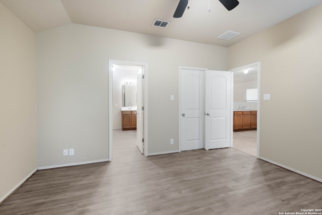 unfurnished bedroom featuring light hardwood / wood-style flooring, ceiling fan, vaulted ceiling, and connected bathroom