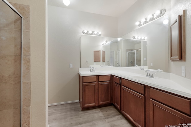 bathroom featuring vanity, hardwood / wood-style flooring, and a shower with door