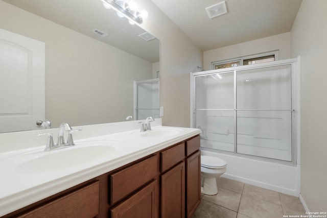 full bathroom with tile patterned floors, toilet, a textured ceiling, shower / bath combination with glass door, and vanity