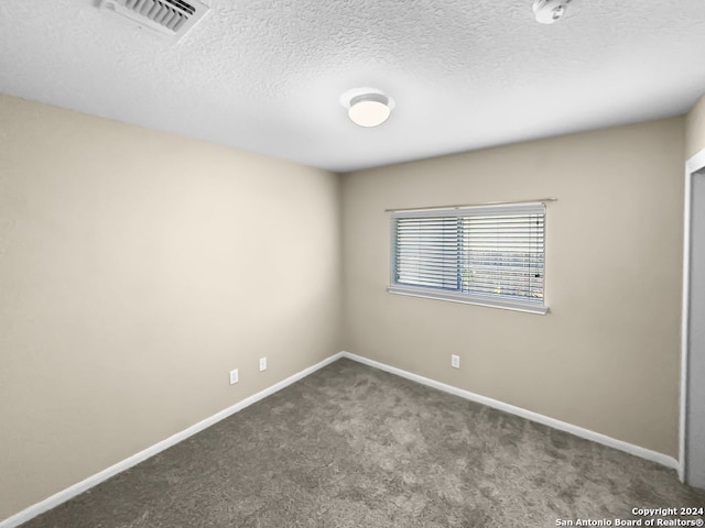 carpeted spare room with a textured ceiling