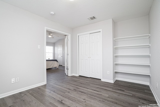 unfurnished bedroom featuring dark hardwood / wood-style flooring and a textured ceiling