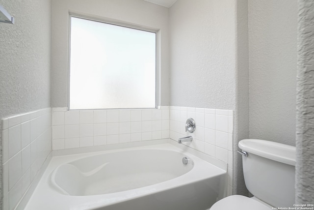 bathroom featuring toilet and a tub