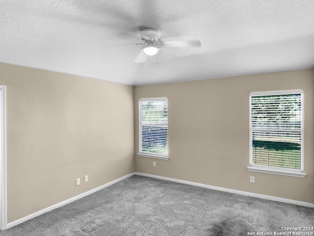 carpeted spare room with ceiling fan and a textured ceiling