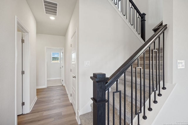 staircase with hardwood / wood-style floors