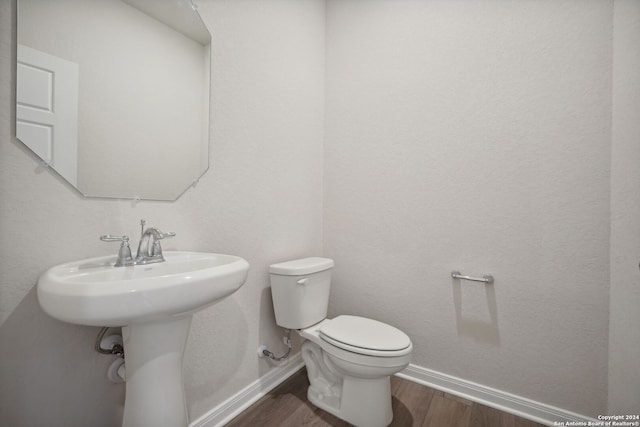 bathroom with toilet and hardwood / wood-style flooring