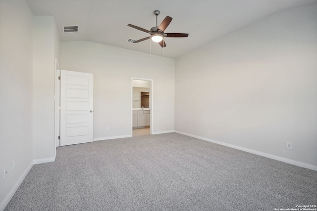 unfurnished bedroom featuring carpet floors, ensuite bathroom, vaulted ceiling, and ceiling fan