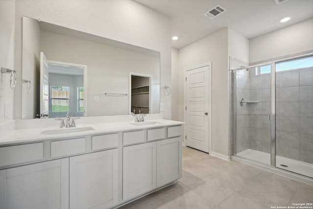 bathroom with tile patterned flooring, vanity, and a shower with shower door