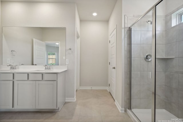 bathroom with tile patterned flooring, vanity, and walk in shower