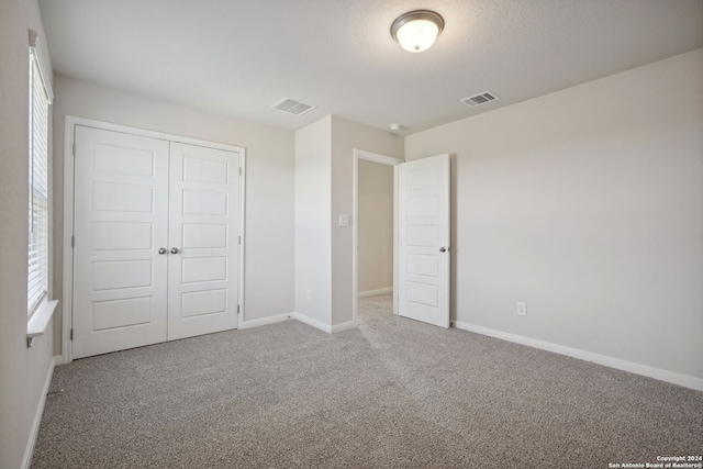 unfurnished bedroom featuring carpet floors and a closet