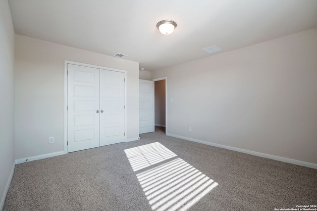 unfurnished bedroom featuring carpet flooring and a closet