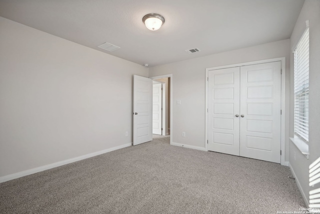 unfurnished bedroom with carpet and a closet