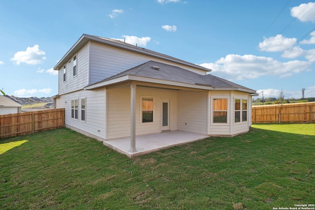 rear view of house with a lawn and a patio