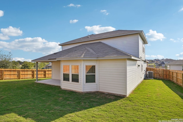 rear view of house featuring central air condition unit, a yard, and a patio