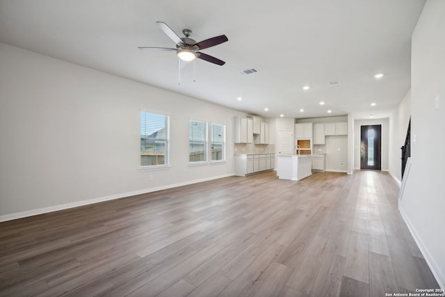 unfurnished living room with ceiling fan and light wood-type flooring