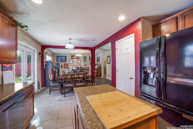 kitchen featuring black refrigerator with ice dispenser, an inviting chandelier, decorative light fixtures, stainless steel dishwasher, and french doors