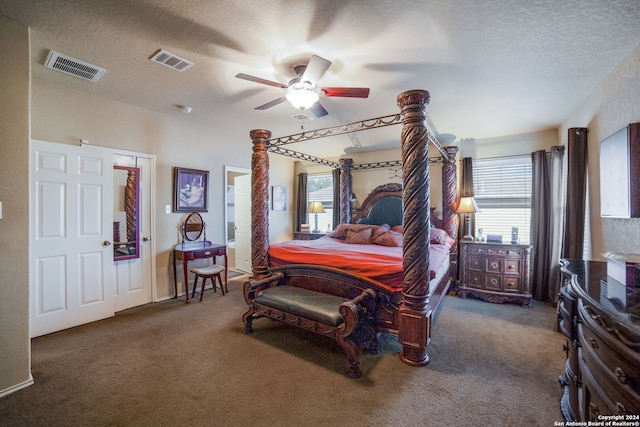 bedroom with a textured ceiling, dark carpet, and ceiling fan