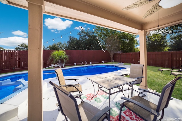 view of pool with a diving board, a lawn, and a patio