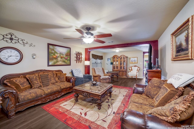 living room with ceiling fan and dark hardwood / wood-style flooring