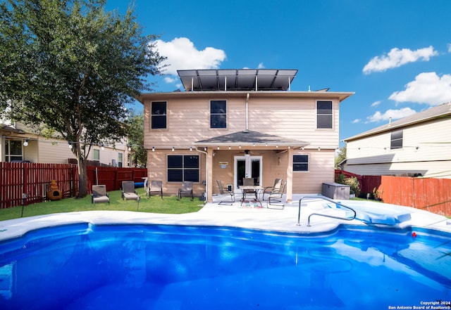 view of swimming pool featuring cooling unit, a lawn, and a patio area