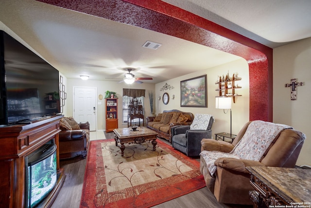 living room featuring hardwood / wood-style floors, ceiling fan, and a textured ceiling