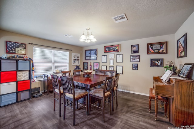 dining area with dark wood-type flooring, a chandelier, and a textured ceiling