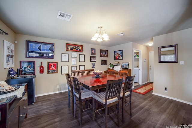 dining room with dark hardwood / wood-style flooring and a notable chandelier