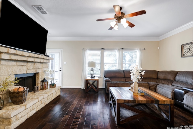 living room with a stone fireplace, ceiling fan, dark hardwood / wood-style floors, and crown molding