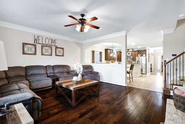 living room featuring ceiling fan, light wood-type flooring, and crown molding