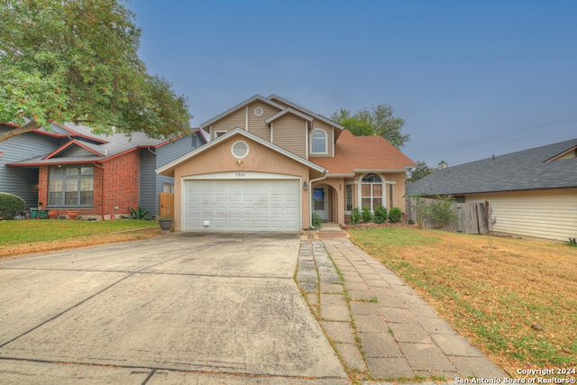 view of property with a garage and a front yard