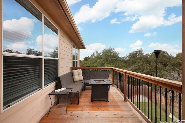 wooden deck with an outdoor living space with a fire pit