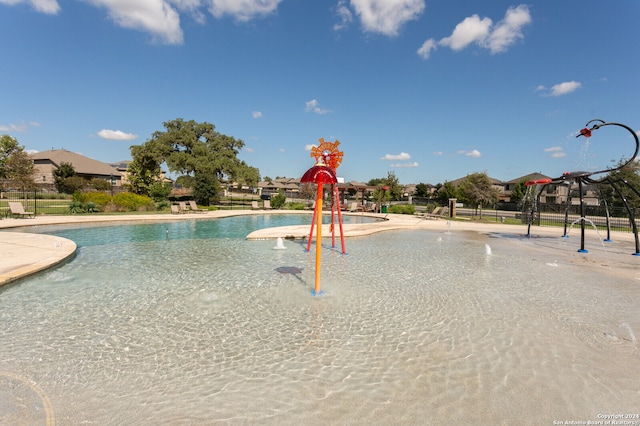 view of pool with pool water feature and a playground