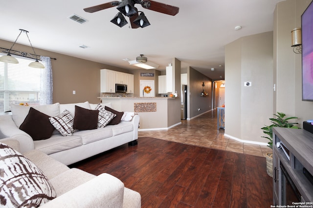 living room featuring ceiling fan and dark wood-type flooring