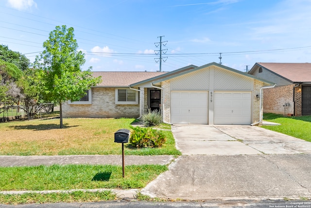 single story home featuring a garage and a front yard