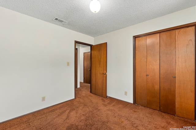 unfurnished bedroom with a closet, a textured ceiling, and light colored carpet