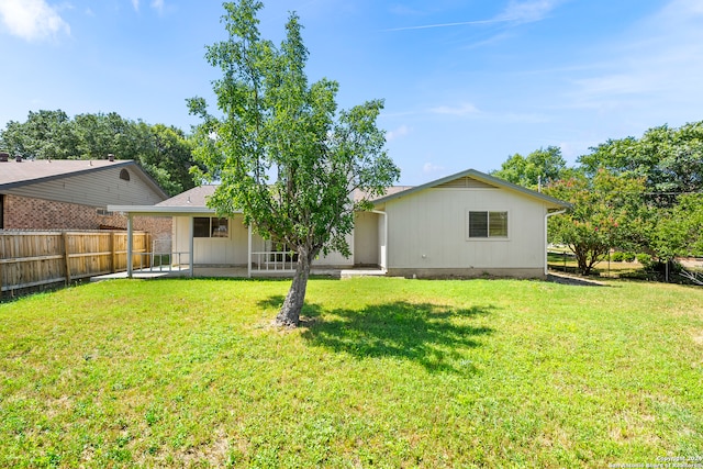 back of house with a patio and a lawn