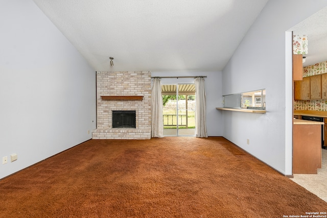 unfurnished living room featuring a fireplace, a textured ceiling, light carpet, and lofted ceiling