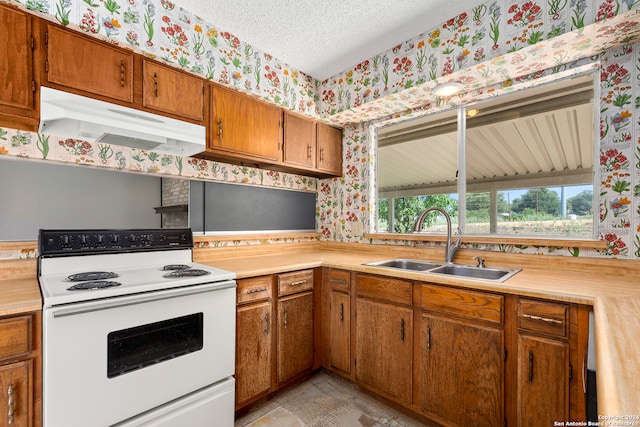 kitchen featuring a textured ceiling, sink, and white range with electric stovetop