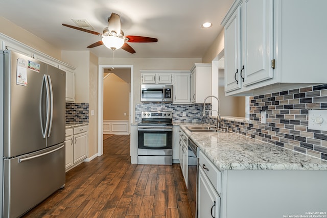 kitchen with white cabinetry, appliances with stainless steel finishes, tasteful backsplash, ceiling fan, and dark wood-type flooring