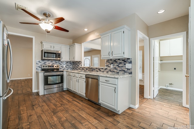 kitchen with hardwood / wood-style flooring, tasteful backsplash, sink, ceiling fan, and appliances with stainless steel finishes