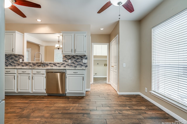 kitchen with a wealth of natural light, stainless steel dishwasher, white cabinets, and ceiling fan with notable chandelier