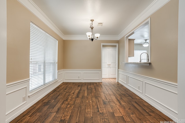 unfurnished dining area featuring ornamental molding, dark hardwood / wood-style floors, and ceiling fan with notable chandelier