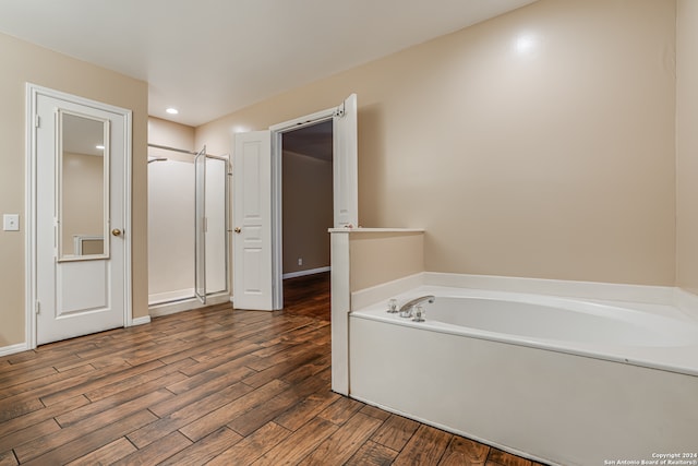 bathroom featuring wood-type flooring and separate shower and tub