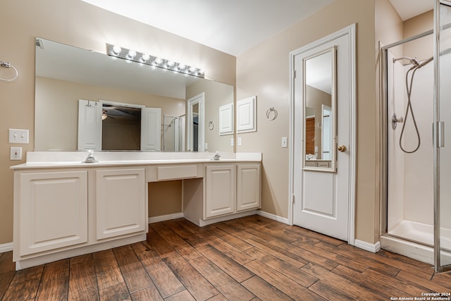 bathroom with hardwood / wood-style flooring, a shower with door, and vanity