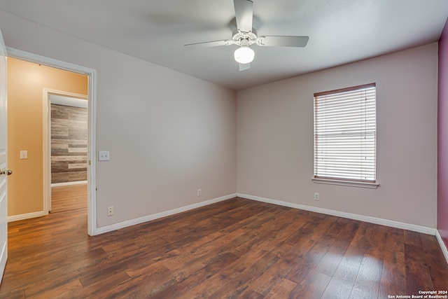 empty room with dark hardwood / wood-style floors and ceiling fan