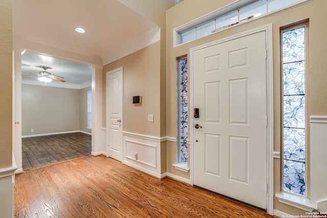 entryway featuring hardwood / wood-style floors, ceiling fan, and crown molding